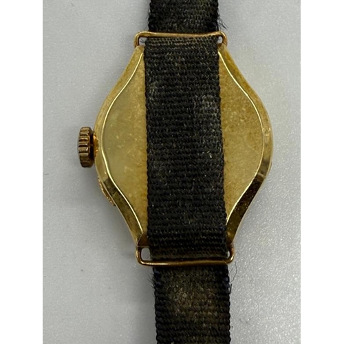 644 - An 18ct gold ladies watch on a fabric strap.