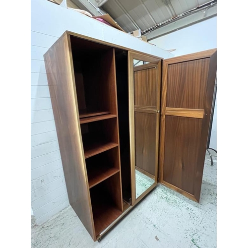 79 - An Ercol style double wardrobe, the sliding mirrored door moves to reveal shelves and hanging rail t... 