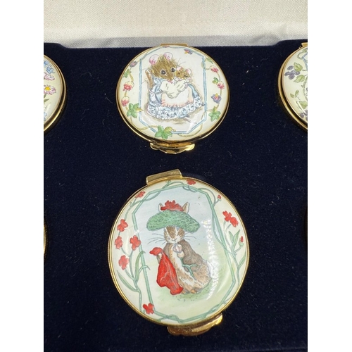 303 - A boxed set of six Royal Doulton enamel pill pots