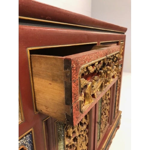 42 - Chinese wedding cabinet of red and gold lacquer, the front panels and doors profusely carved in pier... 