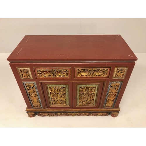 42 - Chinese wedding cabinet of red and gold lacquer, the front panels and doors profusely carved in pier... 