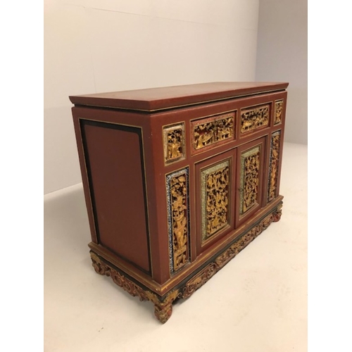 42 - Chinese wedding cabinet of red and gold lacquer, the front panels and doors profusely carved in pier... 