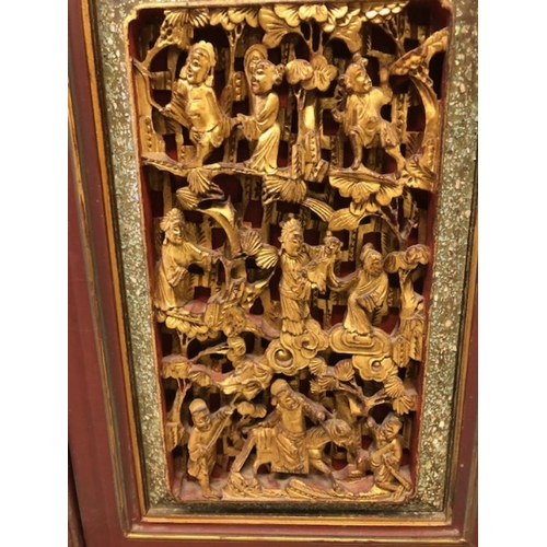 42 - Chinese wedding cabinet of red and gold lacquer, the front panels and doors profusely carved in pier... 
