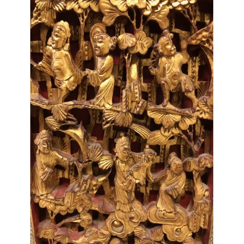 42 - Chinese wedding cabinet of red and gold lacquer, the front panels and doors profusely carved in pier... 