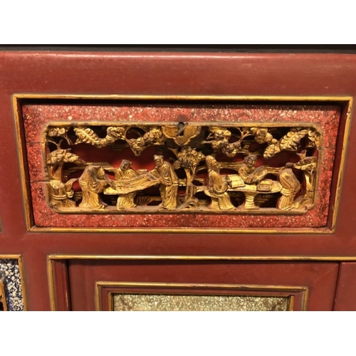 42 - Chinese wedding cabinet of red and gold lacquer, the front panels and doors profusely carved in pier... 