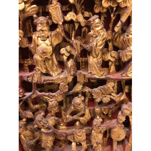 42 - Chinese wedding cabinet of red and gold lacquer, the front panels and doors profusely carved in pier... 