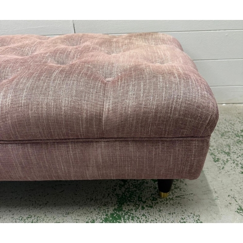 56 - A button topped ottoman, upholstered in a purple and white flecked fabric
