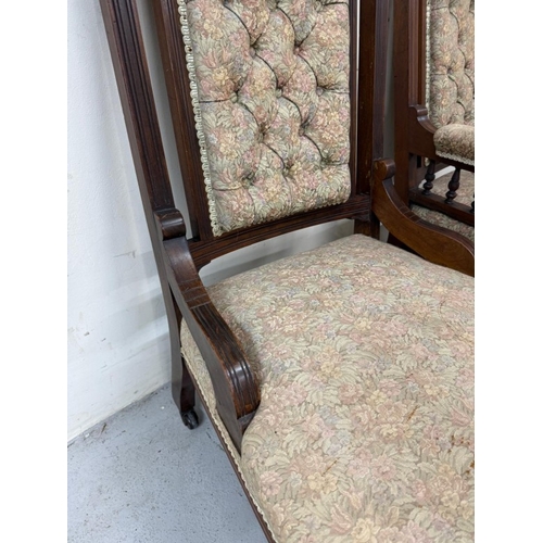 131 - A pair of mahogany-framed his and her fireside chairs in a floral damask fabric