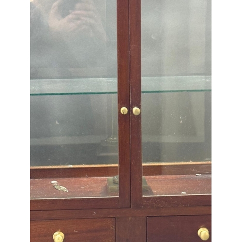 133 - A mahogany-glazed table top display cabinet with two drawers under