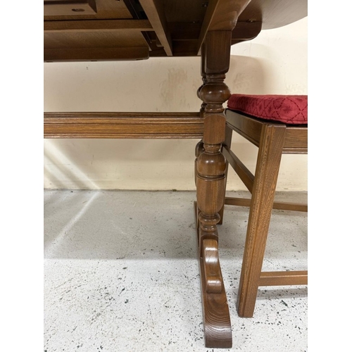 142 - An extendable dark Ercol dining table and four slat back chairs with red upholstered seats H73cm W15... 