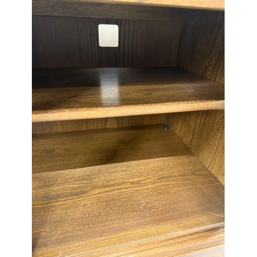 147 - A dark Ercol Tv or media unit with glazed two door cupboard under H56cm W97cm D50cm