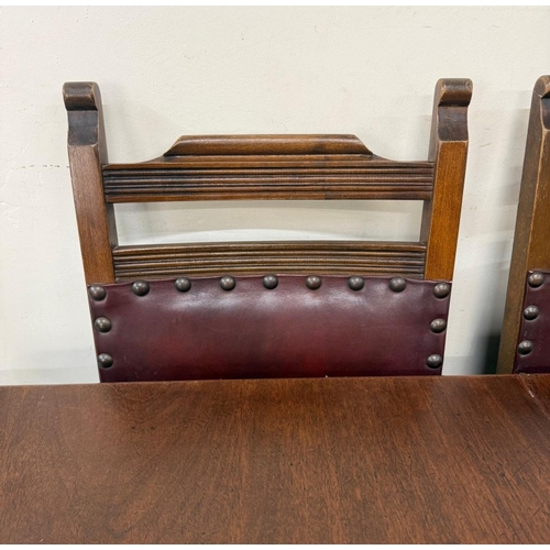 150 - A mahogany extendable dining table on turned legs and a set of six oak framed dining chairs with red... 