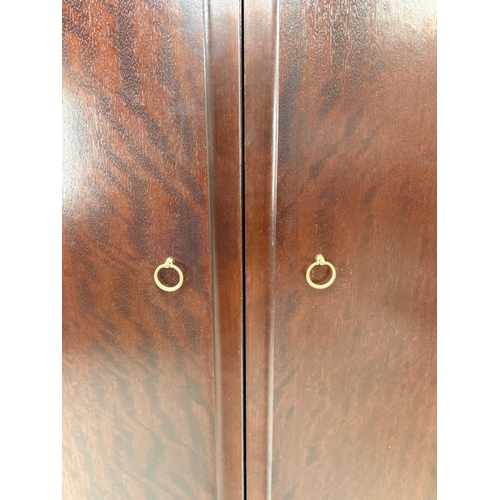 153 - A Stag two-door dark wood wardrobe with two internal cross rails and a single shelf H178cm W1126cm D... 