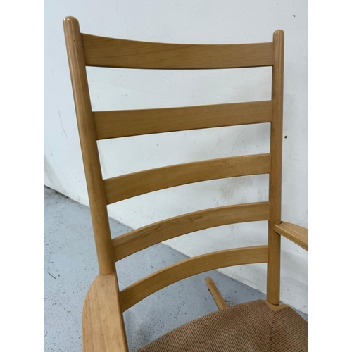 158 - A teak slat back rush seated rocking chair and footstool