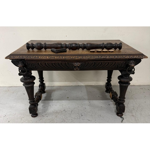 170 - A Belgian oak heavily carved writing table in the Henry II style with drawers flanked by lion head a... 