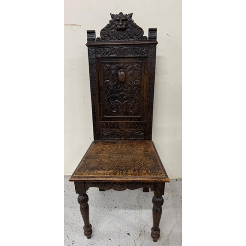 171 - An oak Jacobean-style hall chair with a heavily carved back ad on turned legs