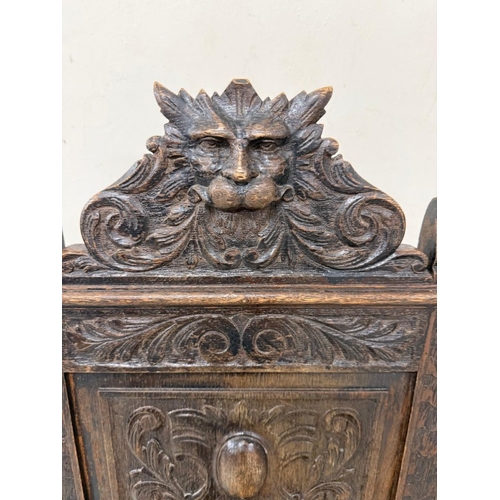 171 - An oak Jacobean-style hall chair with a heavily carved back ad on turned legs
