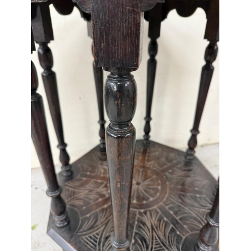 172 - An oak Anglo- Raj style octagonal table  with heavily foliate carvings, turned legs and shelf under ... 