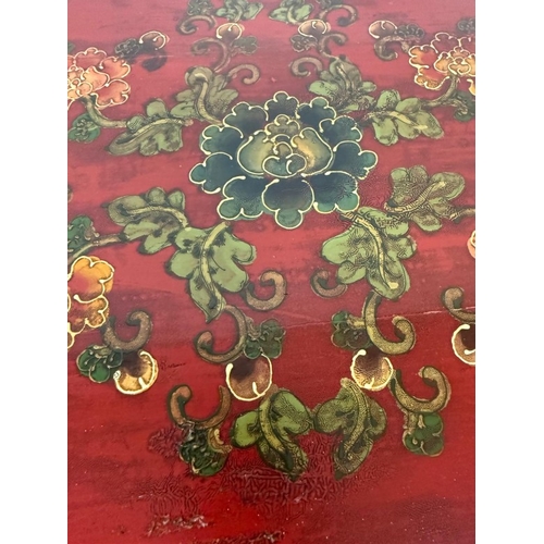 2 - A Chinese style hall cabinet with two cupboards, red grounds and decorated with green and gilt flowe... 