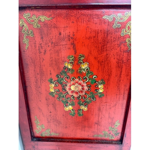 2 - A Chinese style hall cabinet with two cupboards, red grounds and decorated with green and gilt flowe... 