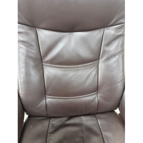 43 - A brown leather stressless reclining armchair and matching footstool
