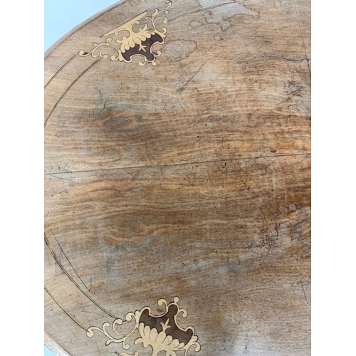 50 - A burr walnut inlaid oval centre table on carved outswept legs and with central finials H75cm W105cm... 