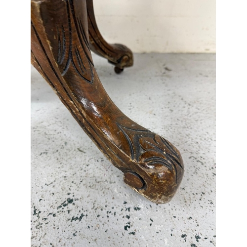 50 - A burr walnut inlaid oval centre table on carved outswept legs and with central finials H75cm W105cm... 