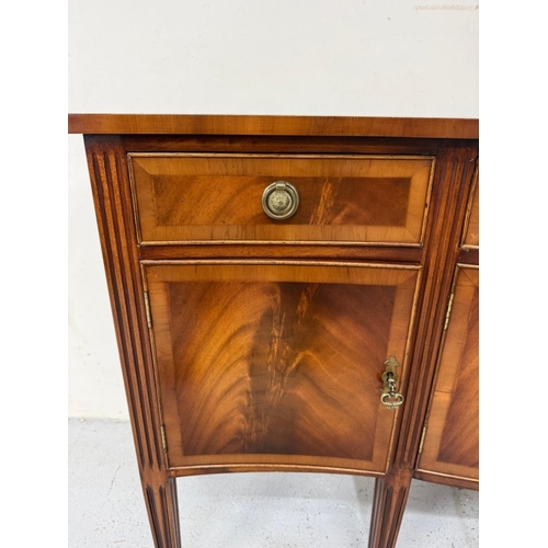 56 - A Regency style serpentine fronted veneered sideboard on fluted legs H92cm W160cm D47cm