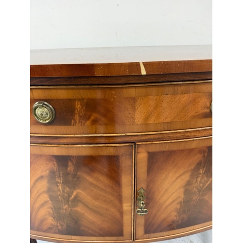 56 - A Regency style serpentine fronted veneered sideboard on fluted legs H92cm W160cm D47cm