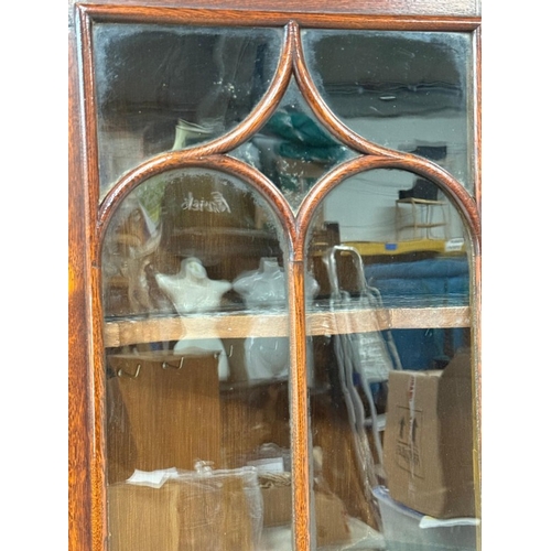 58 - A mahogany free-standing corner cupboard comprising a two-door cupboard with two door astragal glaze... 
