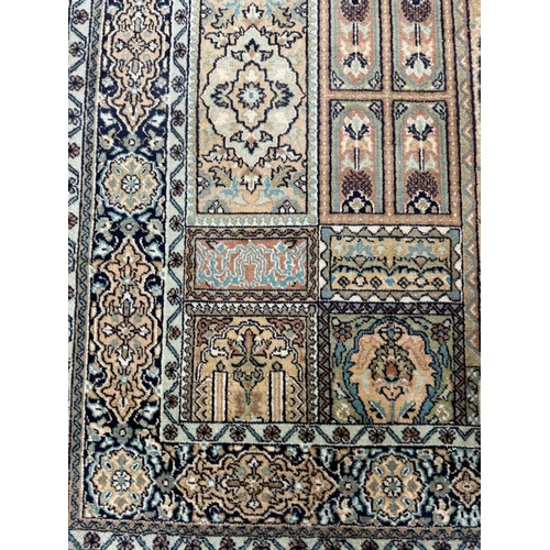 190 - A wool rug with beige ground and a geometric border 160cm x 93cm