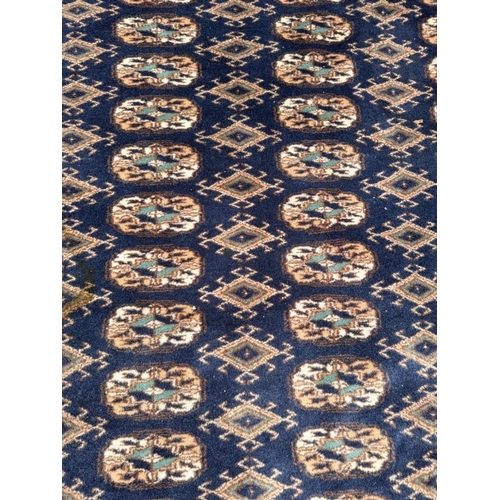 191 - A wool rug with blue ground, red and blue geometric boarder 168cm x 245cm