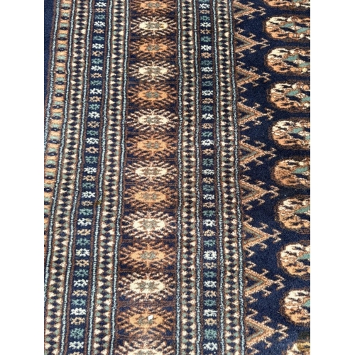 191 - A wool rug with blue ground, red and blue geometric boarder 168cm x 245cm