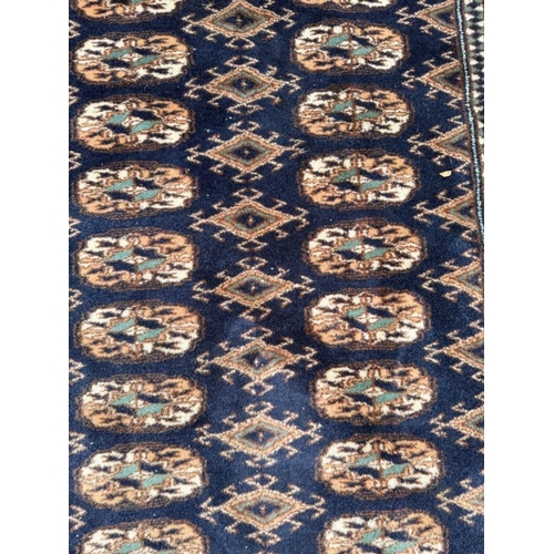 191 - A wool rug with blue ground, red and blue geometric boarder 168cm x 245cm