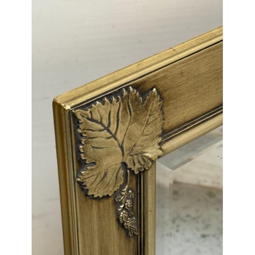 192 - A gold bevel edged over mantle mirror with fig leaf detail to corners Width 106cm x Height 76cm.