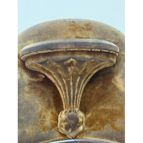 198 - A circular bevel-edged overmantel mirror, the surrounding frame upholstered in mustard yellow velvet... 