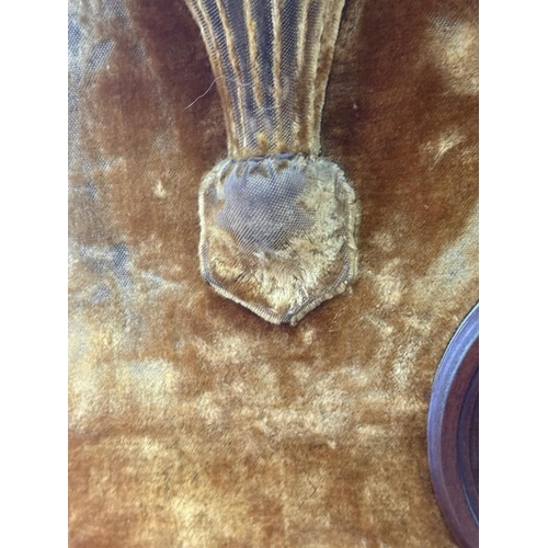 198 - A circular bevel-edged overmantel mirror, the surrounding frame upholstered in mustard yellow velvet... 