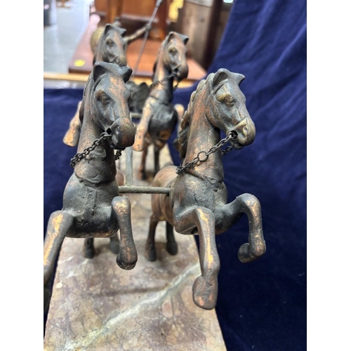240 - A bronze sculpture featuring a Roman warrior in a four-horse chariot mounted on a marble plinth