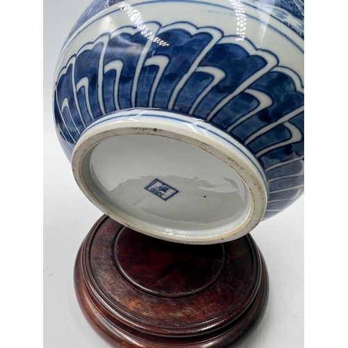 270 - A Japanese blue and white double gourd vase featuring a continuous landscaped scene, signed to base ... 