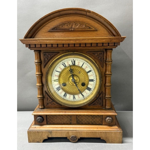 383 - An oak cased German 14-day mantel clock with brass and enamel face, Roman numeral and carved pedimen... 