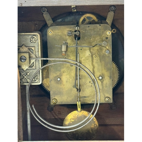 383 - An oak cased German 14-day mantel clock with brass and enamel face, Roman numeral and carved pedimen... 