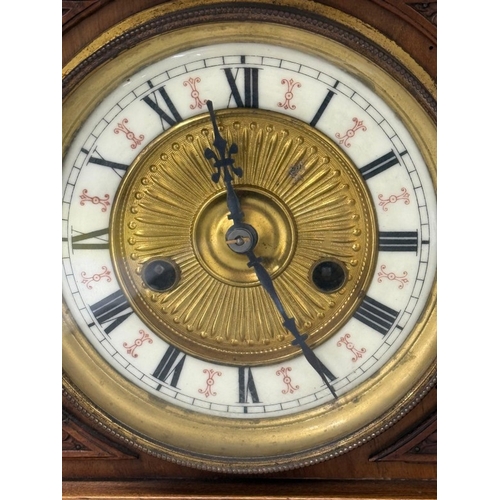 383 - An oak cased German 14-day mantel clock with brass and enamel face, Roman numeral and carved pedimen... 