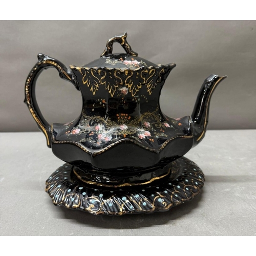 126 - A black gilt florally painted tea pot and stand