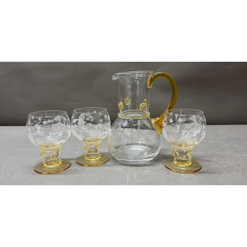 150 - A yellow amber and clear glass pitcher and four matching glasses with an etched vine leaf motif