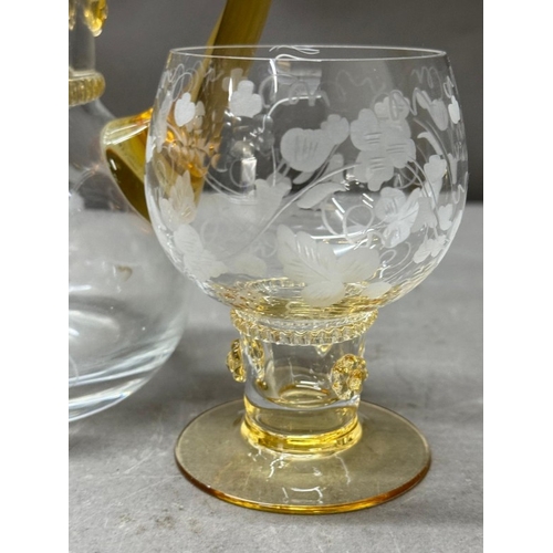 150 - A yellow amber and clear glass pitcher and four matching glasses with an etched vine leaf motif