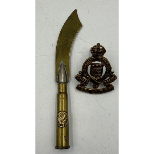 37 - A Trench Art letter opener along with an Army Ordnance Cap Badge.