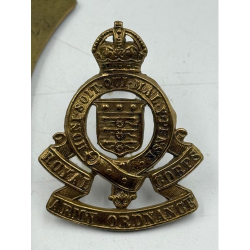 37 - A Trench Art letter opener along with an Army Ordnance Cap Badge.