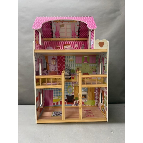39 - A Dolls House with pink roof and multiple colourful rooms.
