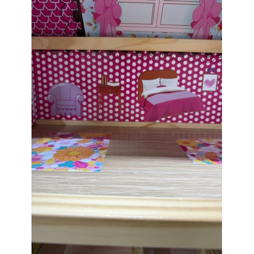 39 - A Dolls House with pink roof and multiple colourful rooms.