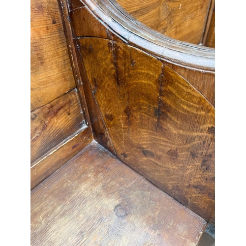 134 - An oak four seater church pew with gothic carved panels and scrolling arms H90cm W260cm D39cm